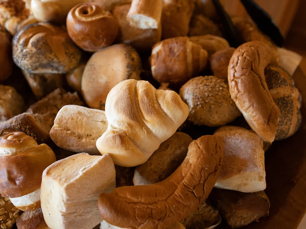 Verschiedene Brötchen und Backwaren auf einem Holzbrett
