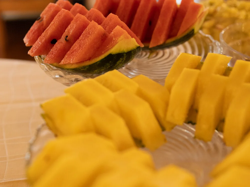 Gedeckter Tisch mit geschnittenen Wassermelonen und anderen Früchten
