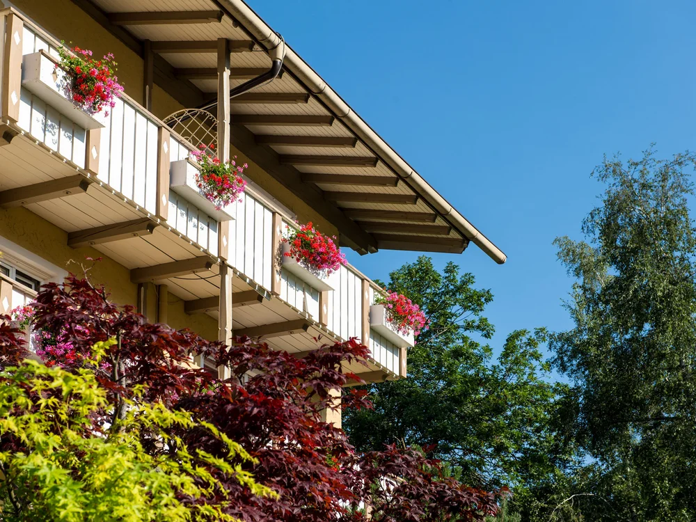 Balkone mit bunten Blumen an einem Gebäude bei klarem Himmel