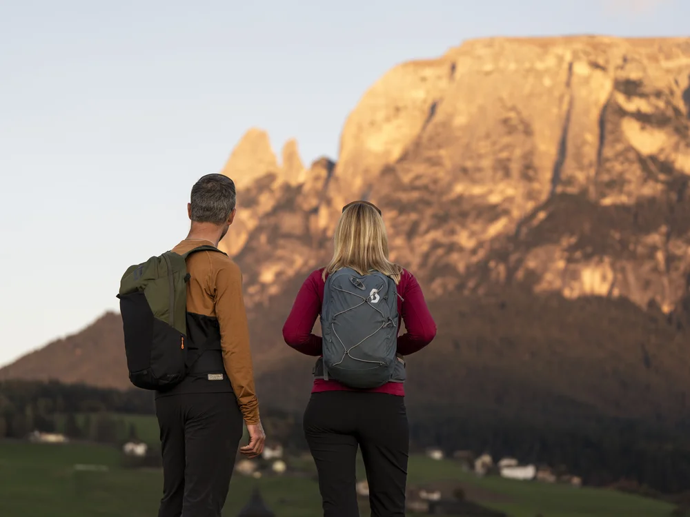 Zwei Wanderer mit Rucksäcken vor einer beeindruckenden Berglandschaft