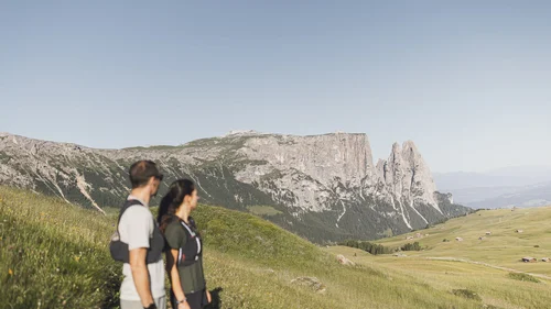 Paar wandert in den Bergen mit Blick auf eine Felsformation im Hintergrund