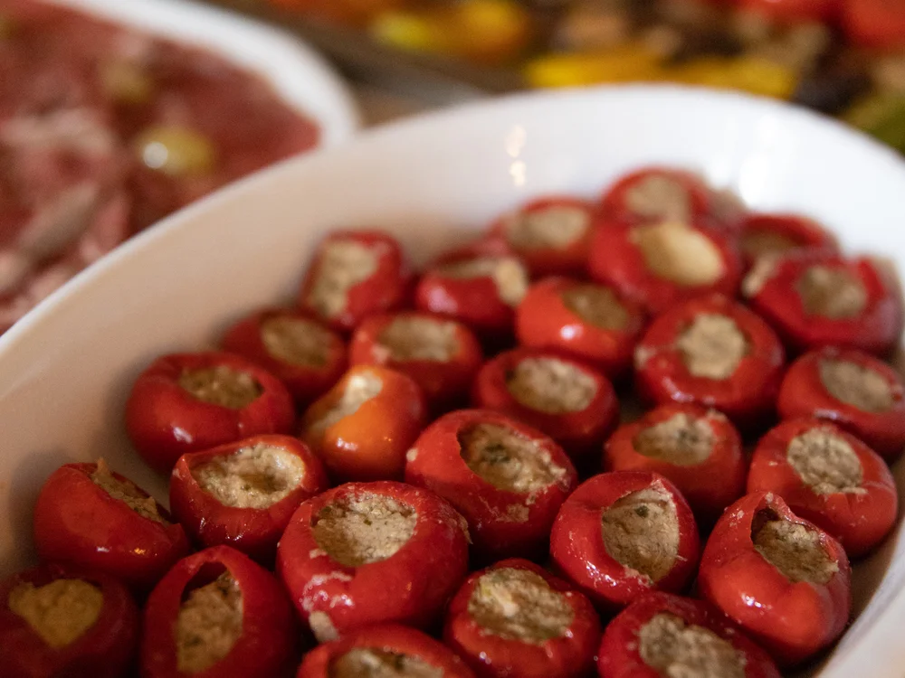 Rote gefüllte Chilischoten auf einem weißen Teller nah aufgenommen