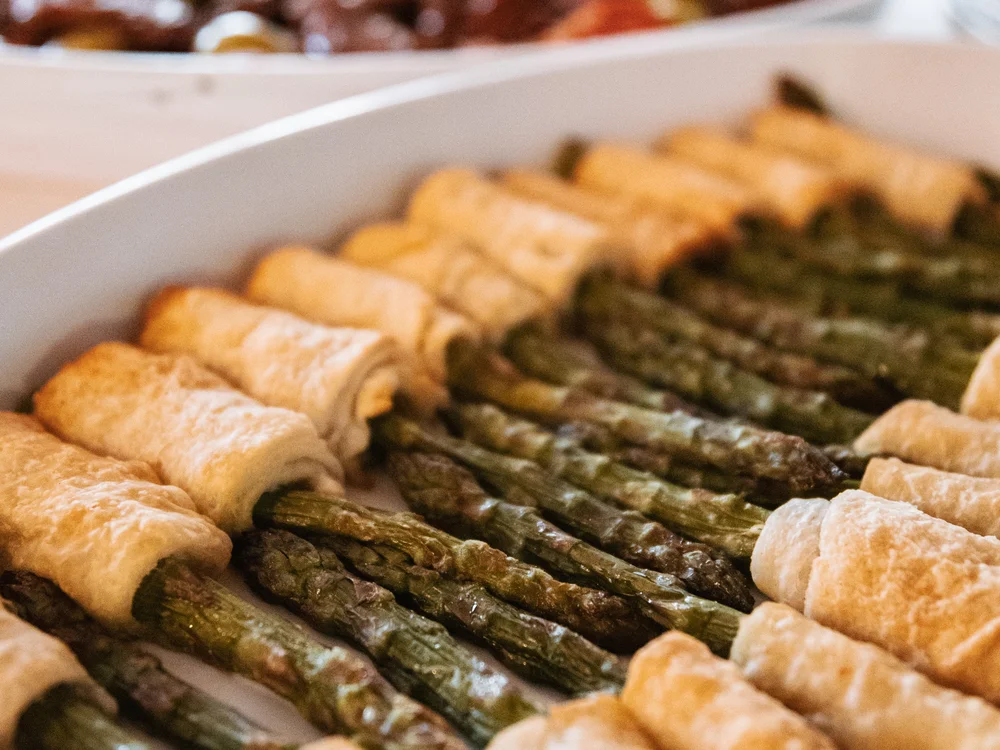 Grüner Spargel in Blätterteig auf einem weißen Teller angerichtet
